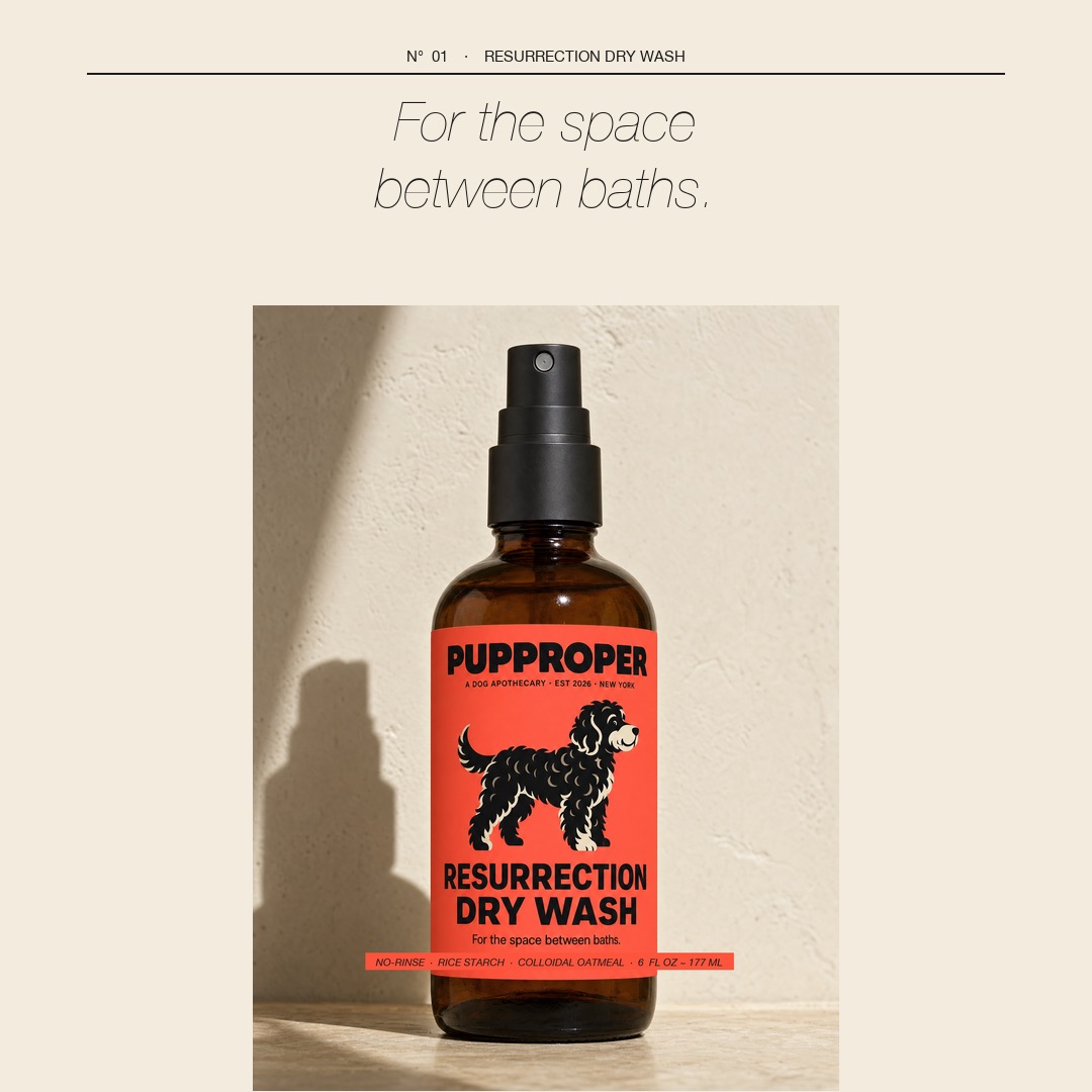 Resurrection Dry Wash — amber bottle against warm plaster, 'For the space between baths'